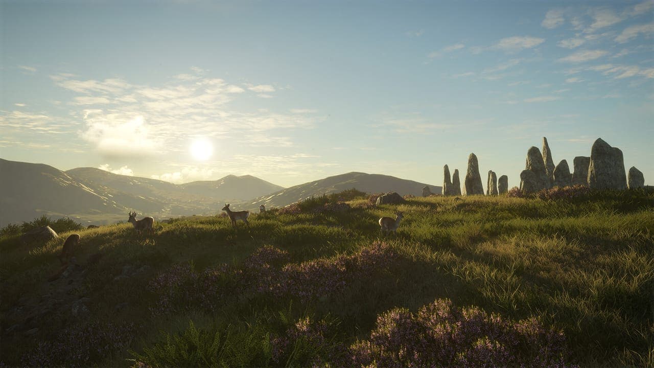 A ring of tall standing stones on a heather-covered hilltop at sunrise, with several deer grazing and mountains behind, in theHunter: Call of the Wild