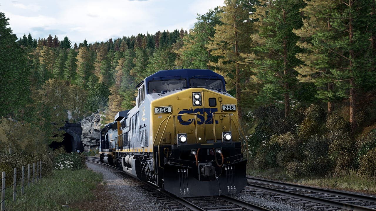Two CSX diesel locomotives leading a freight train out of a tunnel on a forested hillside in Train Sim World
