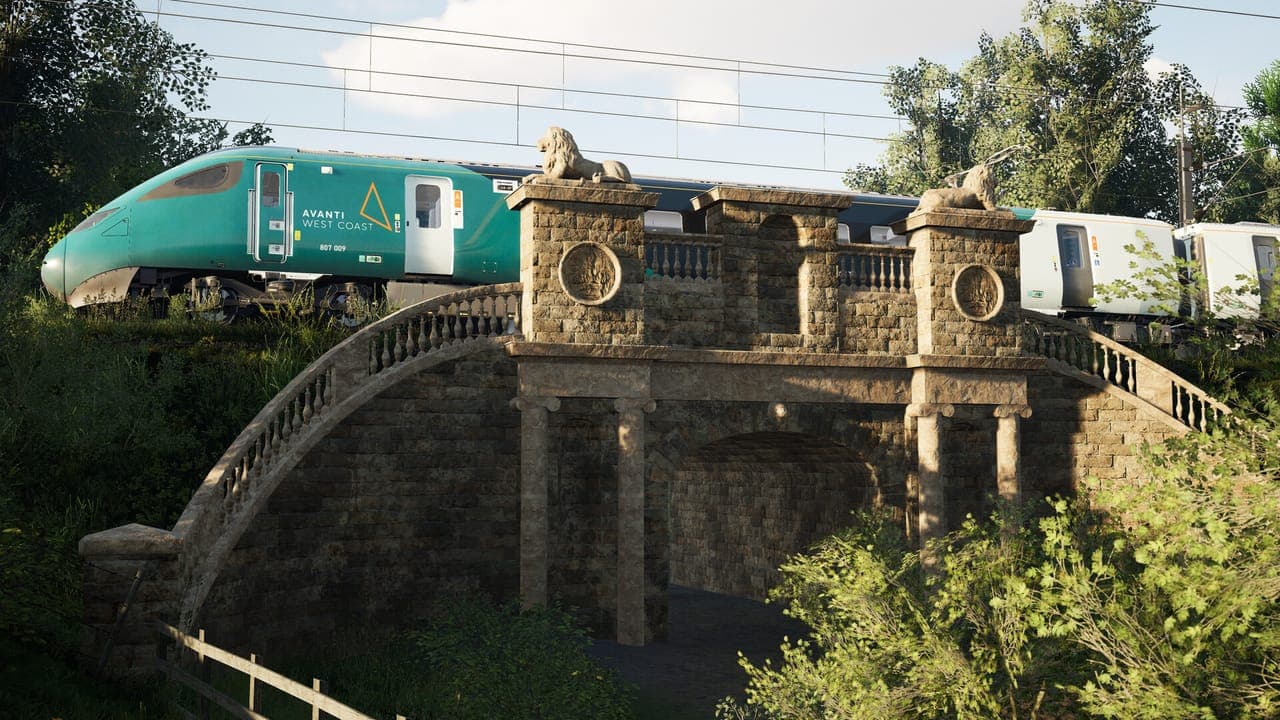 A teal and white Avanti West Coast high-speed train crossing behind an ornate stone bridge with lion statues, surrounded by trees, in Train Sim World